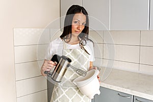 Cropped image of female chef mixing batter in bowl with hand mixer