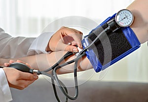 Cropped image of Female doctor checking blood pressure of patient at table