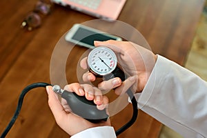 Cropped image of Female doctor checking blood pressure of patient at table