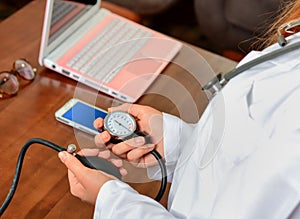 Cropped image of Female doctor checking blood pressure of patient at table