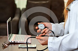 Cropped image of Female doctor checking blood pressure of patient at table