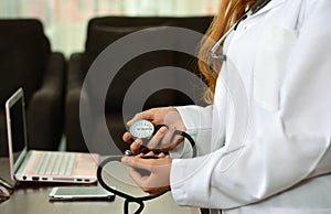 Cropped image of Female doctor checking blood pressure of patient at table