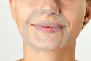 Cropped image of female face, nose, lips and chin  on white background. Plastic surgery, filler, lip