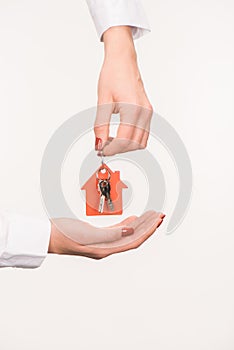 cropped image of female hands holding key from house