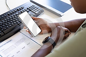 Cropped image of female professional using smart phone with copy space at computer desk in office