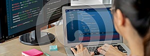 Female developer coding on laptop while computer display program. Burgeoning.