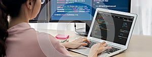 Female developer coding on laptop while computer display program. Burgeoning.