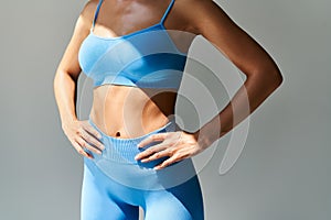 Cropped image of fit woman torso on grey background