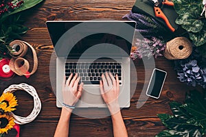 cropped image of florist working with laptop