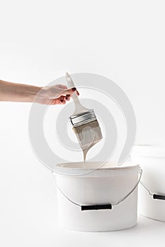 Cropped image of girl holding brush with dripping white paint