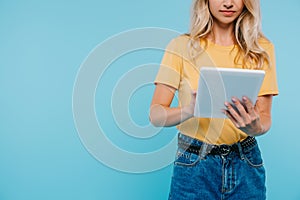 cropped image of girl in shirt and shorts using tablet
