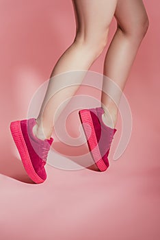 cropped image of girl in stylish sneakers standing on toes