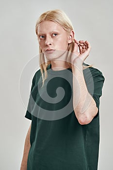 Cropped image of guy cleaning his ear with ear stick