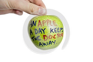 Cropped image of hand holding a granny smith apple with sayings text over white background