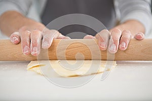 cropped image hands rolling pastry
