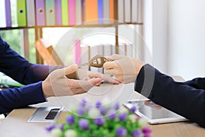 Cropped image of hands of sales car dealership giving keys to customer