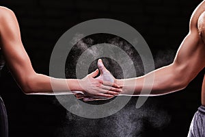 Cropped image of hands of a young couple on dark background. Crossfit fitness, bodybuilding concept
