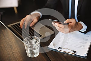 Cropped image of a handsome young businessman using phone