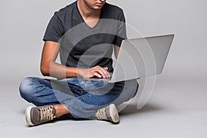 Cropped image of a happy smiling casual man sitting on the floor with laptop