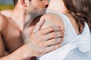 cropped image of heterosexual couple hugging and kissing