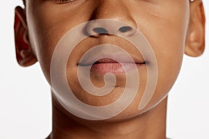 Cropped image of little boy face. Macro, close up parts of face. Chin, nose and mouth