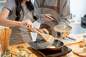 Cropped image of a lovely couple enjoying making pancakes in a minimalist kitchen together