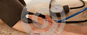 Cropped image of male doctor checking blood pressure of patient at table