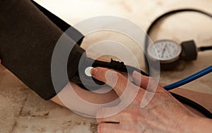 Cropped image of male doctor checking blood pressure of patient at table