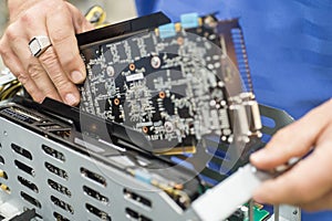 Cropped image of male engineer repairing video card in computer manufacturing industry