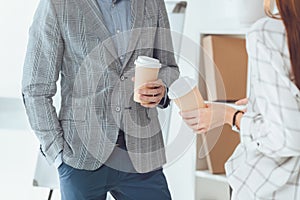 cropped image of male and female colleagues having coffee break