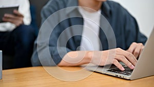Cropped image, A male freelancer or college student using laptop, typing on keyboard