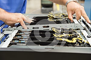 Cropped image of male technician examining computer card slots in electronics industry