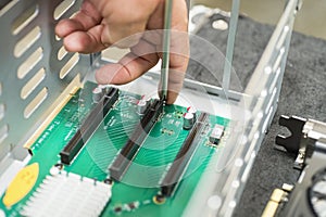 Cropped image of male technician repairing PCI slots in computer factory