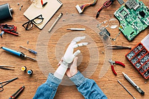 cropped image of man with amputee putting off prosthetic arm on table photo