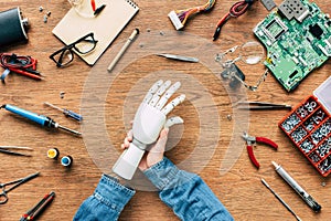 cropped image of man with amputee putting on robotic hand on table photo