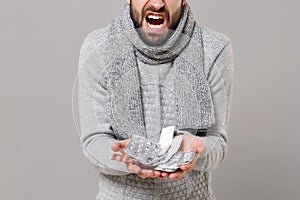 Cropped image of man in gray sweater, scarf isolated on grey background. Healthy lifestyle, ill sick disease treatment