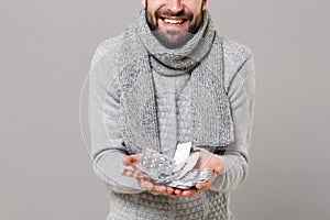 Cropped image of man in gray sweater, scarf isolated on grey background. Healthy lifestyle, ill sick disease treatment