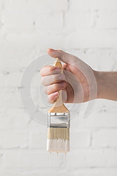 Man holding brush in white paint