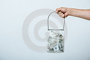 cropped image of man holding glass jar with dollars