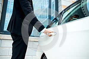 Cropped image of man opening door on his executive car