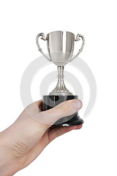 Cropped image of man's hand holding winning trophy over white background