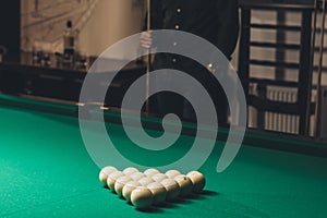 cropped image of man standing behind of gambling billiard table with set of russian