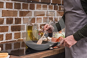 cropped image of man stirring vegetables