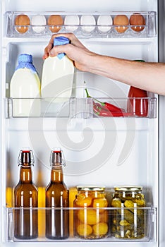 cropped image of man taking bottle of milk