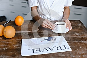 Cropped image of mixed race girl in white robe taking cup of coffee in morning