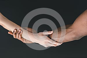 cropped image of multicultural couple holding hands photo