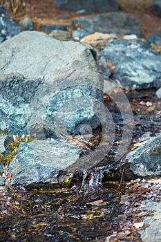 Cropped image of natural waterfall, water falling over the stone