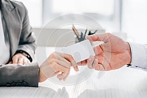 cropped image of patient giving id card to doctor