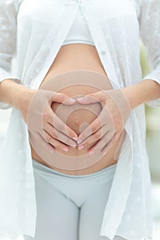 Cropped image of pregnant woman hugging the tummy