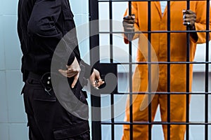 cropped image of prison guard putting hand on gun